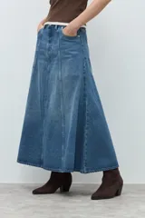 Falda midi de jean en color azul medio, con diseño de paneles verticales y corte acampanado. Presenta cierre frontal con botón y bolsillos laterales.