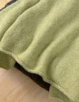 Sweater de punto color verde matcha, con diseño oversized, cuello redondo y mangas largas amplias.