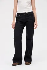 Jean de corte oxford en color negro, con ajuste en cintura y caderas, y piernas amplias. Presenta un diseño estructurado con cierre de botón y cremallera, y bolsillos clásicos.