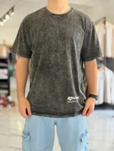 Remera oversize de color bordó con efecto gastado acid wash, mangas cortas y estampa en la espalda con texto y logo.