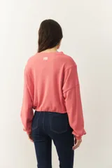 Buzo celeste cropped de manga larga con puños y cordones ajustables en la cintura.