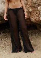 Pantalón negro de gasa brillante, con elástico en la cintura y calce relajado.