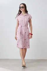 Vestido camisero midi a rayas verticales rosas y blancas con bordados florales multicolores, cuello camisero, mangas cortas y cinturón de lazo.