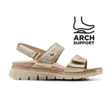 Sandalia casual de mujer con tiras ajustables de velcro en color dorado metalizado. Presenta una plantilla ergonómica con soporte de arco y una suela de plataforma dentada en tono beige con detalles lineales dorados.