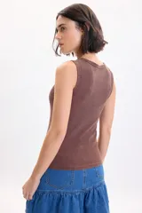 Musculosa marrón de tejido rib, cuello redondo y diseño ajustado.