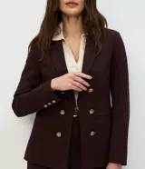 Blazer femenino de sastrería confeccionado en tejido Punto Roma, con cuello solapa, cierre frontal con ganchos y botones decorativos dorados con escudo grabado.