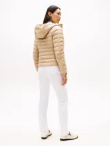 Campera acolchada ultraliviana de nailon reciclado, color beige, con capucha y cierre frontal. Presenta diseño acolchado horizontal y bolsillos laterales con cierre.