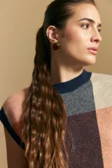 Chaleco tejido de punto con diseño de bloques a cuadros en tonos rosados, marrones y beige. Presenta cuello redondo y terminaciones acanaladas en cuello y sisas.