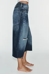 Bermuda de jean tiro medio, corte baggy y diseño holgado con detalle de rotos y cinco bolsillos.