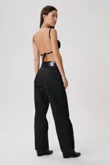 Pantalón de jean color beige claro, tiro medio, con corte ancho y pierna recta. Presenta costuras visibles en tono contrastante.