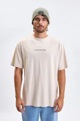 Remera de corte oversize color beige, con estampa en la espalda que incluye nombres de personajes de Star Wars acompañados de sus ilustraciones lineales.