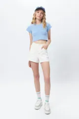 Top corto celeste al cuerpo, de manga corta y cuello redondo.