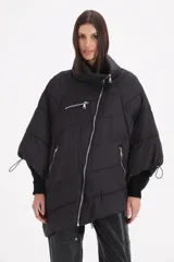 Campera tipo mantela acolchada de color negro, con cierre frontal cruzado, cuello alto y mangas amplias con puños elásticos ajustables. Presenta bolsillos laterales y un bolsillo frontal con cierre.