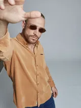 Camisa marrón de pana de manga larga con cuello abotonado y bolsillo en el pecho.