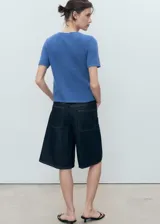 Cardigan de punto de algodón con diseño de manga corta, cuello redondo y cierre frontal con botones.