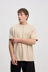 Remera de manga corta color beige con tejido texturado y pequeño logo impreso en el pecho.
