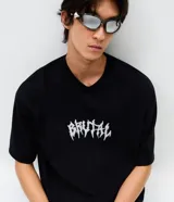 Remera de corte oversized en color negro, con cuello redondo y manga corta. Presenta un estampado frontal con la palabra 'Brutal' en tipografía estilo metal y un estampado de esqueleto en la espalda.