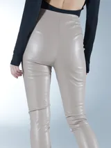 Pantalón de cuero sintético en color beige, de corte ajustado y tiro alto, con cierre frontal y bolsillos laterales.