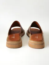 Sandalias de cuero color chocolate, con faja ancha en el empeine, plantilla de gamuza y suela plana con taco bajo.