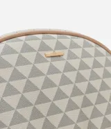 Mochila Viko con estampado geométrico de triángulos en tonos beige y blanco. Presenta un bolsillo frontal con cierre, detalles en color nude y un colgante de pompón de peluche desmontable. Cuenta con correas ajustables y cierre principal con cremallera.