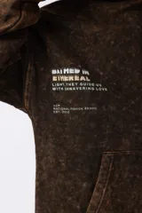 Buzo canguro con capucha, de calce oversize y efecto de lavado ácido en tono marrón. Presenta un bolsillo frontal tipo canguro y un pequeño estampado minimalista en el pecho.