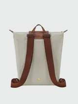 Mochila Longchamp modelo Le Pliage Original tamaño M, de color negro con detalles en cuero marrón y herrajes dorados. Cuenta con solapa con botón a presión, cierre superior y correas ajustables.