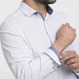 Camisa blanca con microestampado de lunares azules, cuello clásico con botón y puños con botón.