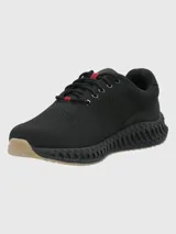 Sneaker de diseño deportivo con capellada de tejido knit negro, cordones al tono con detalle en rojo y suela con estructura tecnológica de amortiguación en color negro con base de goma clara.