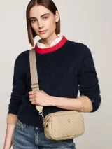 Bandolera Tommy Hilfiger color beige con diseño acolchado en diagonal y logo de la marca en dorado al frente.
