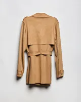 Campera tipo trench de color habano, de corte a la cadera, confeccionada en material textil símil gamuza. Presenta solapa cruzada, doble botonadura frontal, hombreras y cinturón ajustable para anudar en la cintura. Incluye bolsillos delanteros y puños con trabilla.