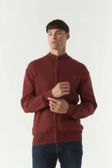 Campera tejida de algodón con cierre frontal completo, cuello alto y puños acanalados. Presenta un logo bordado en el pecho y bolsillos laterales.