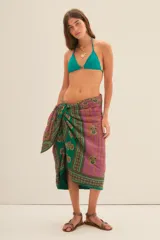 Pareo de tela estampada, anudado a la cintura, con diseño en tonos morados, verdes y detalles en bordó.