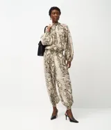 Pantalón tipo aladino confeccionado en chiffon con estampado de piel de serpiente. Presenta cintura alta con elástico y puños ajustados en los tobillos, ofreciendo una silueta holgada y fluida.