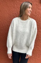 Sweater de punto en color crudo melange, con cuello redondo, mangas largas con puños ajustados y diseño de corte holgado.