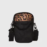 Bolso tipo phone bag de la marca Bubba, confeccionado en cuero vegano negro con detalle superior en estampado animal print. Cuenta con una cadena decorativa negra en el frente, cierre principal y correa ajustable extraíble.