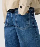 Pantalón de jean premium de tiro medio con corte wide leg, de color azul, con pretina con pasacintos y bolsillos funcionales.
