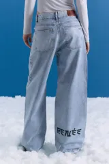 Jean de corte oversize y tiro medio-alto, color celeste con lavado tipo ice y acabado con foil transparente. Presenta diseño de cinco bolsillos y estampa en la pierna trasera.