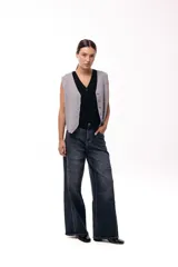 Jean wide leg de tiro medio en color azul oscuro con costuras verticales visibles que aportan estructura. Presenta un corte amplio y relajado con diseño de cinco bolsillos.