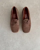 Zapato náutico marrón de cuero vacuno con cordones y suela plana.