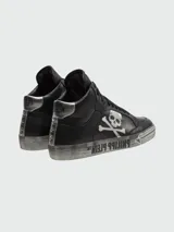 Zapatillas de caña alta Philipp Plein modelo Retrokickz™ color negro con detalles plateados, confeccionadas en cuero. Presentan calavera y huesos cruzados en el lateral, nombre de la marca en la suela y tachas en el talón.