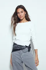 Remera de manga larga color blanco, con ajuste al cuerpo y cuello redondo. Presenta terminaciones con borde ondulado en los puños y el ruedo.