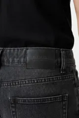 Pantalón jean baggy color gris oscuro con efecto gastado, de tiro medio y corte holgado en las piernas.