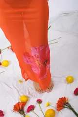 Vestido midi ajustado al cuerpo, color naranja con estampado de una flor roja.