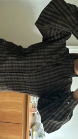 Campera de bengalina con cierre frontal, cuello alto con botón y mangas largas abullonadas con puños abotonados.