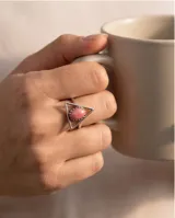 Anillo de plata 925 con diseño triangular y piedra central ovalada de raíz de rubí en tonos rosados.