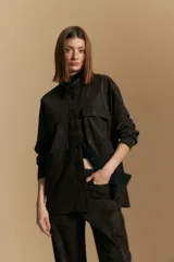 Sobrecamisa de efecto engomado en color negro, con textura lavada, cuello clásico, cierre frontal con botones a tono y bolsillos frontales con solapa.