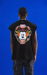 Sudadera sin mangas negra de calce oversize, confeccionada en algodón premium. Presenta un estampado grande en la espalda con la cara de Mickey Mouse usando auriculares, rodeado de elementos gráficos de equipos de música y luces de neón.
