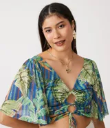 Blusa cropped con estampado de hojas en tonos verdes y azules, escote en V, mangas acampanadas y lazo ajustable en el busto.