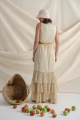 Vestido largo de gasa estampada con flores en tonos de verde y amarillo sobre fondo blanco. Tiene cintura elastizada y terminación en volados.