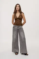 Jean wide leg de tiro medio, con pierna amplia de caída recta, diseño de cinco bolsillos, pasacintos y cierre frontal con botón y cremallera.